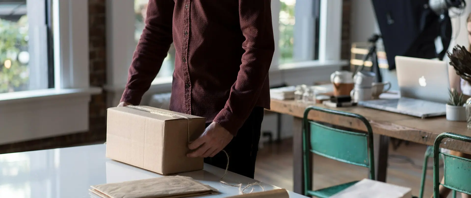 person holding cardboard box on table
