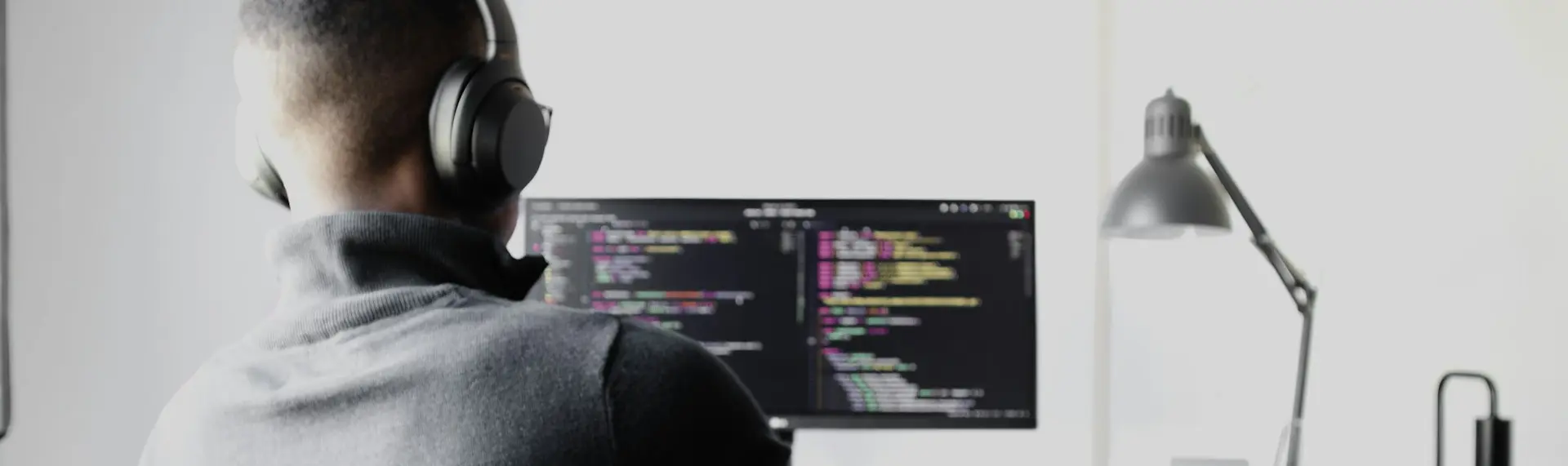 man in black long sleeve shirt wearing black headphones sitting on chair